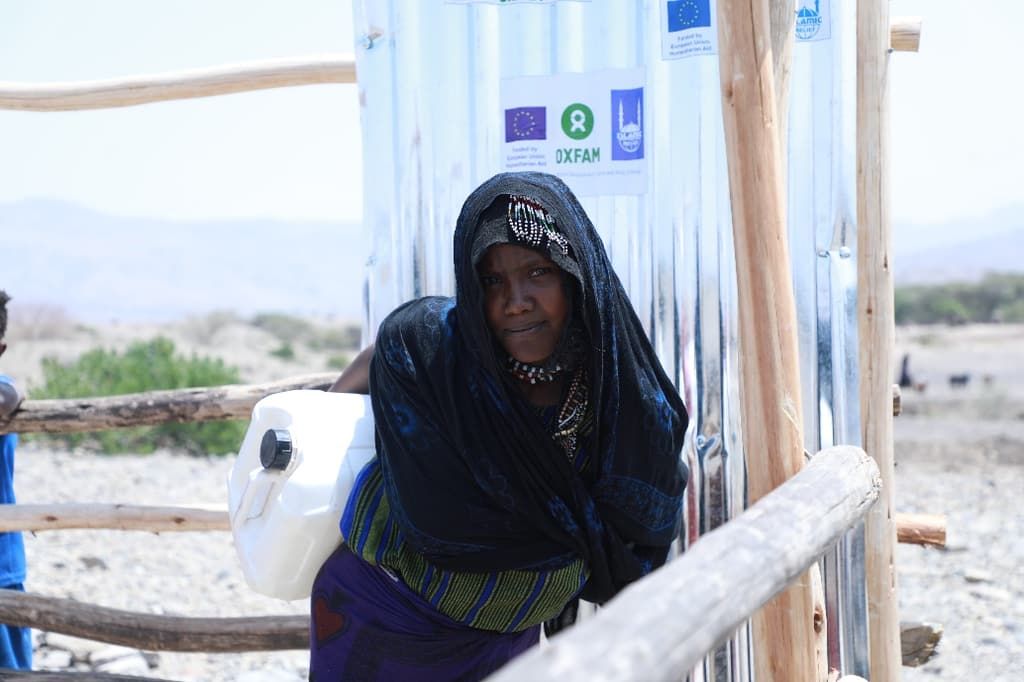 A woman stands beside a newly built latrine block in a rural village in northern Ethiopia.